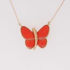 Tour de cou papillon en or jaune et corail rouge.