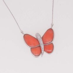 Tour de cou papillon en or blanc, diamants et corail rouge.