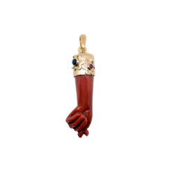 Pendentif main sculptée corail rouge de Méditerranée et calotte or jaune 18k rubis rouge et saphir bleu.
